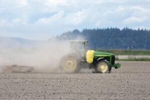 Farmer plowing dry field